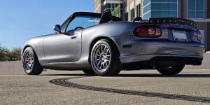 Silver convertible sports car parked outdoors.