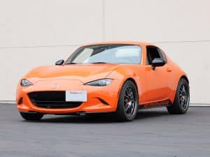 Orange sports car parked outside building.