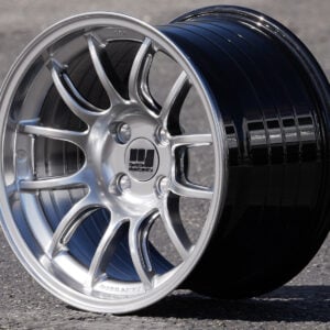 Silver alloy car wheel on asphalt surface