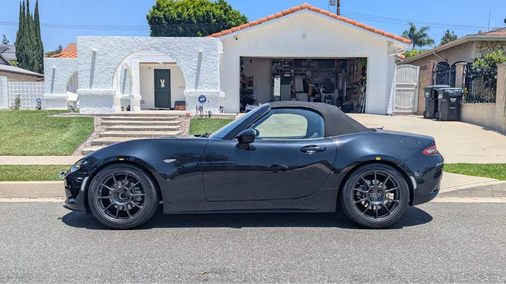 Black convertible parked in suburban driveway